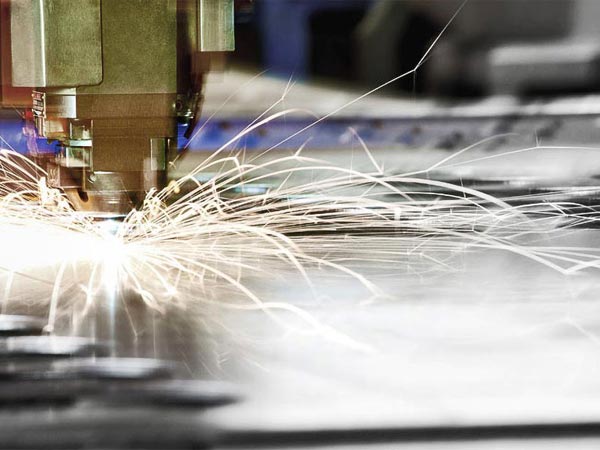 Close-up of machinery cutting metal with bright sparks flying
