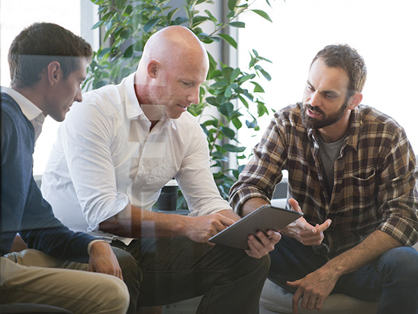 three men in a meeting