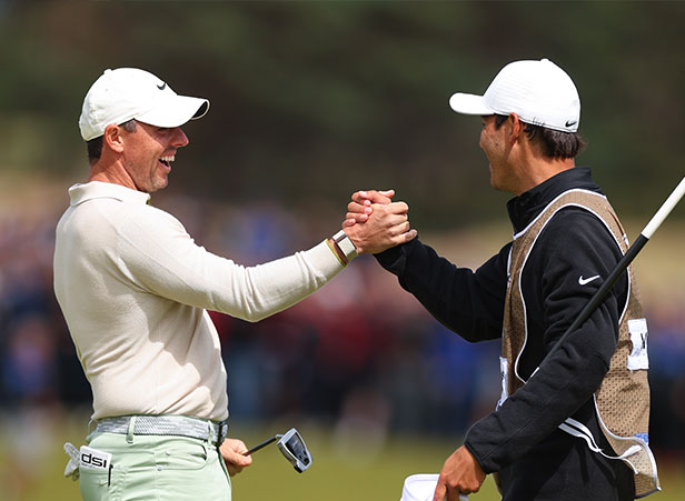 Rory McIlroy and caddie handshake, celebration in golf, teamwork in sports, outdoor sports camaraderie, FM mission of promoting community, golf success moment, sportsmanship in golf, building connections through golf, positive interaction in sports, golf event celebration