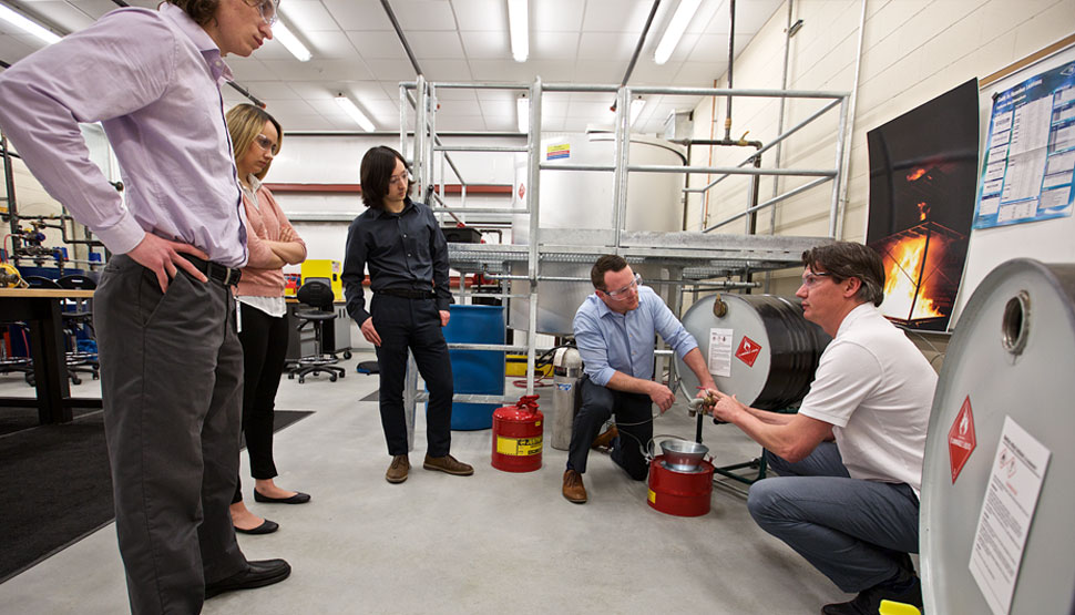 lab group observing equipment demo near safety gear